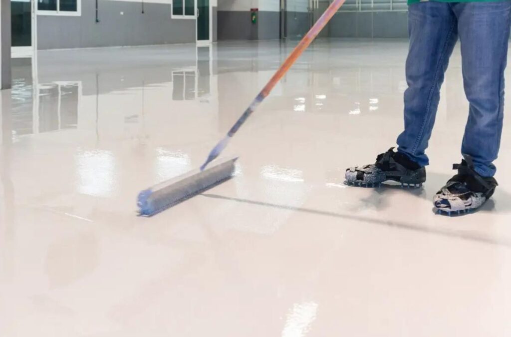 Employee of Expert Epoxy Solutions installing durable epoxy flooring in Southport NC.