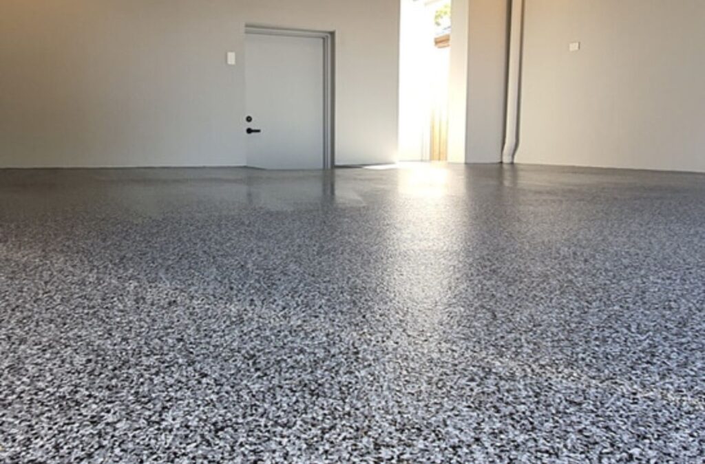 Employee of Expert Epoxy Solutions applying durable epoxy flooring in Topsail Beach NC.